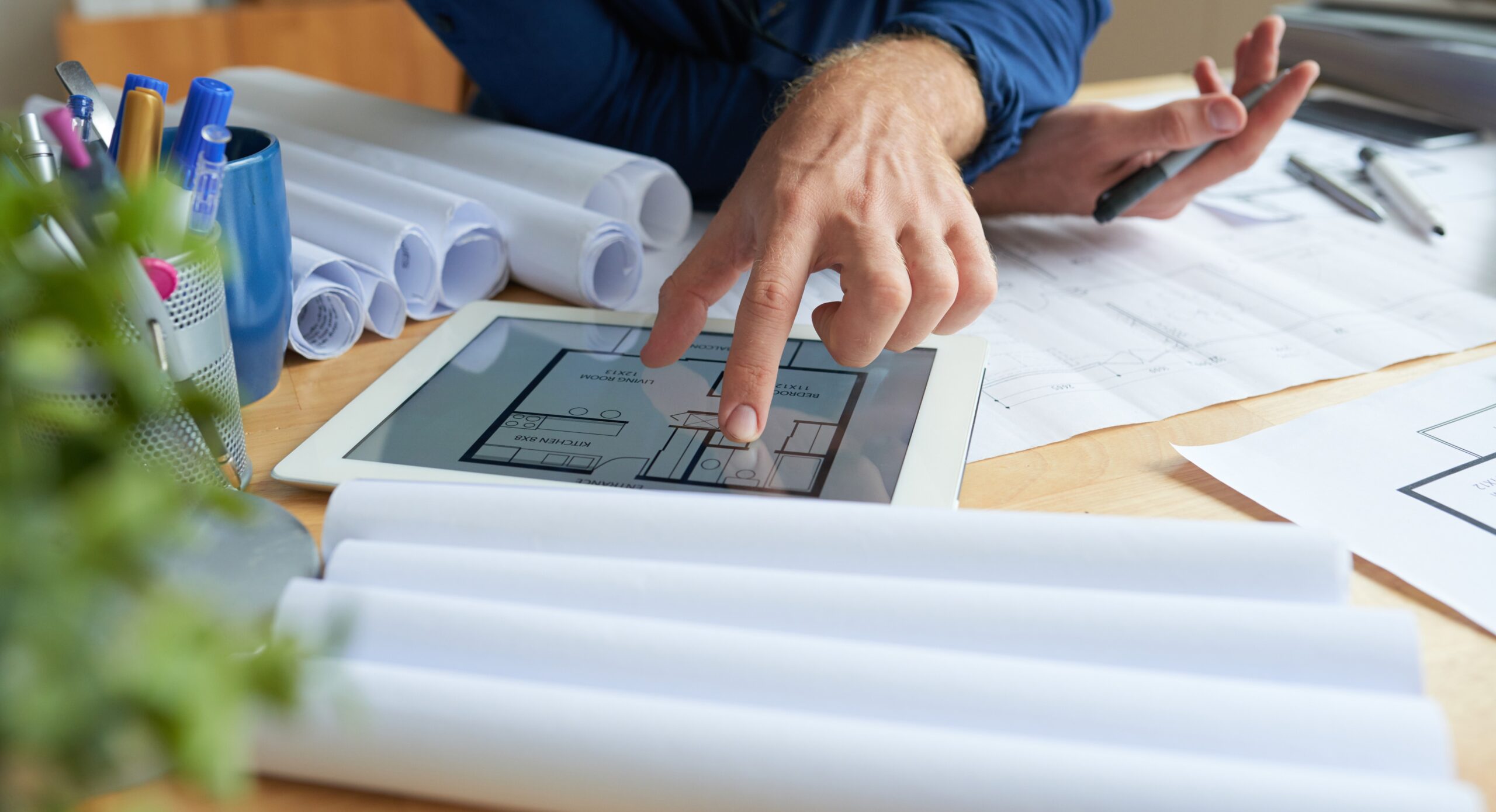 Close-up image of architect examining housing project on screen of tablet computer